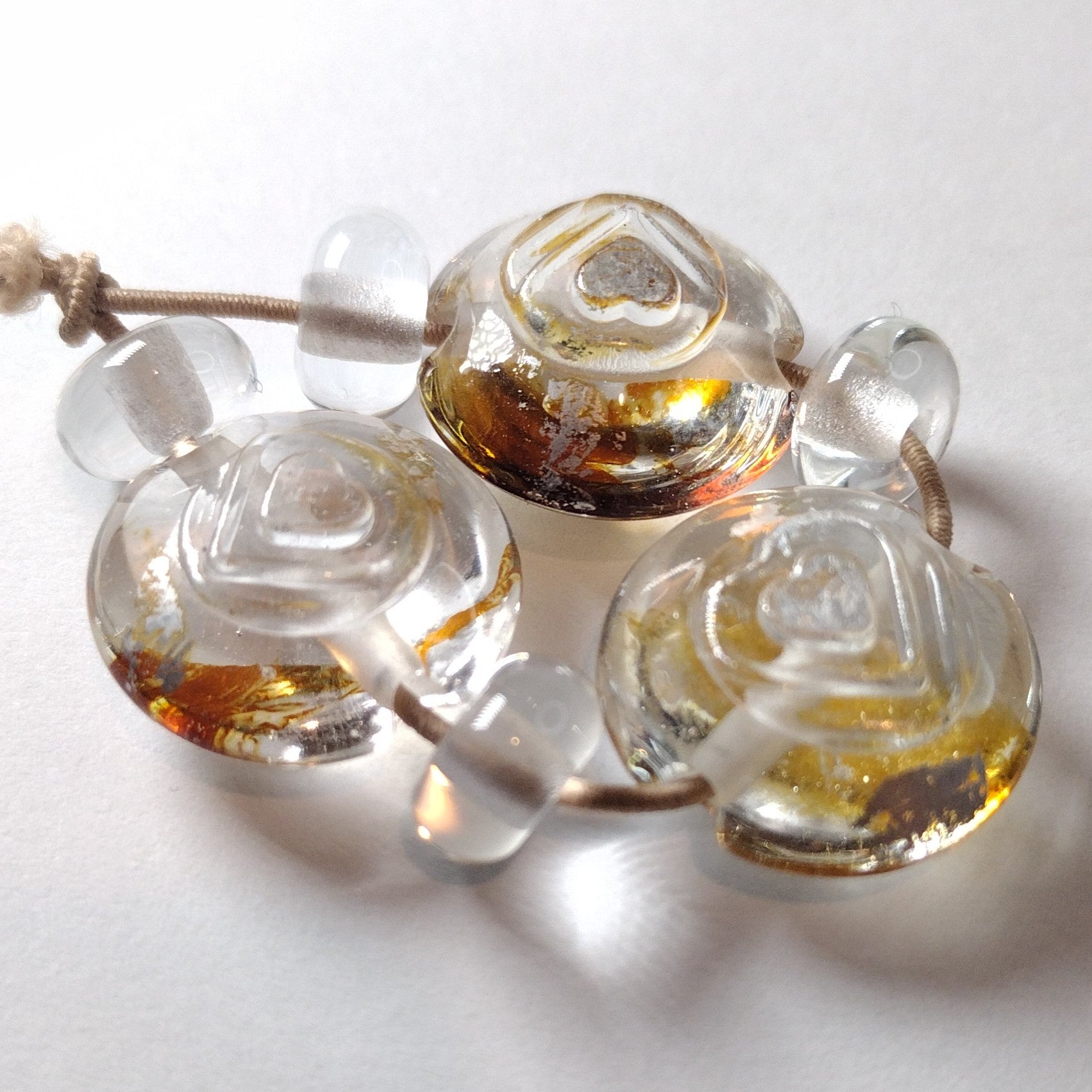 Clear lentil lampwork bead trio with silver leaf burnished over textured hearts Jolene Beads