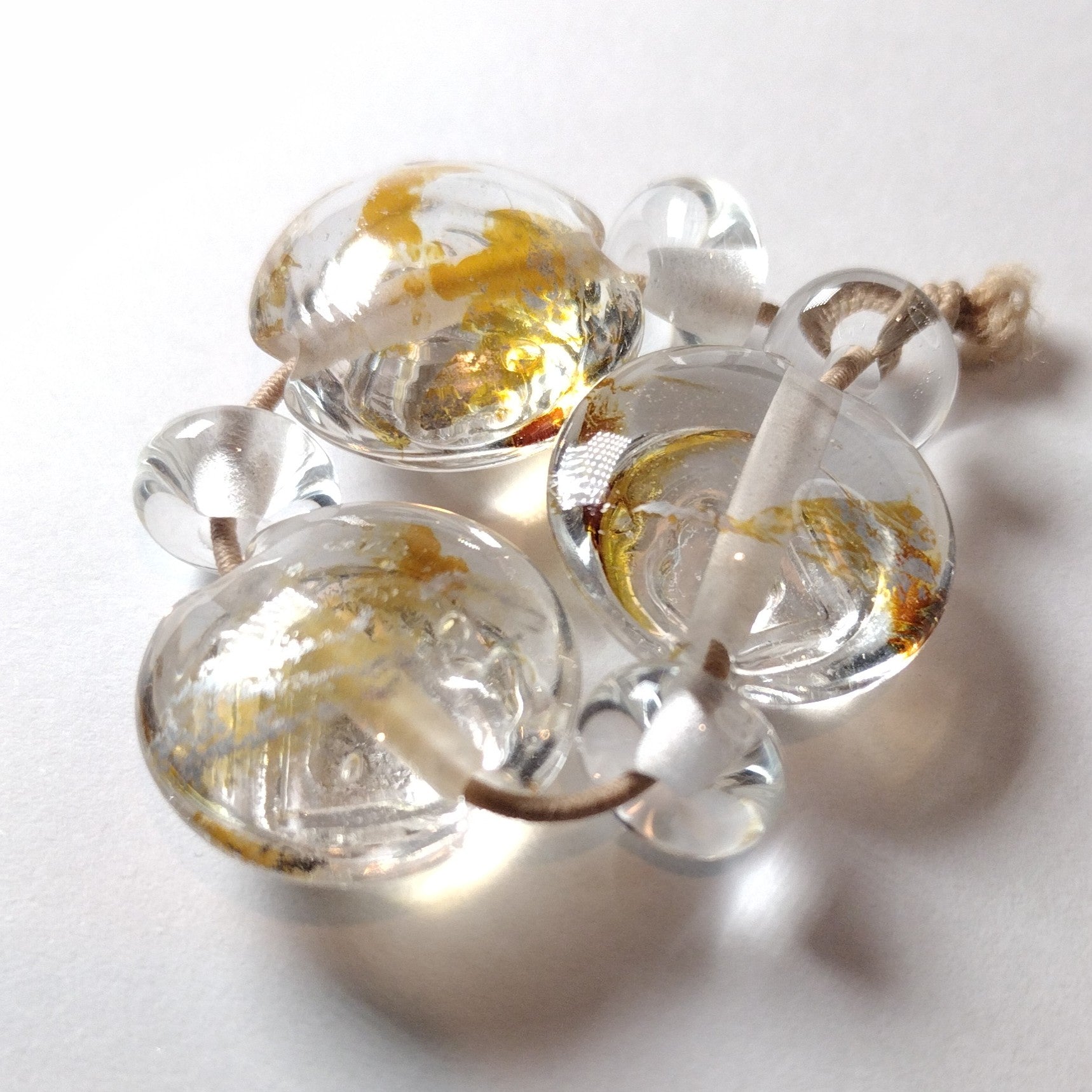 Clear lentil lampwork bead trio with silver leaf burnished over textured hearts Jolene Beads